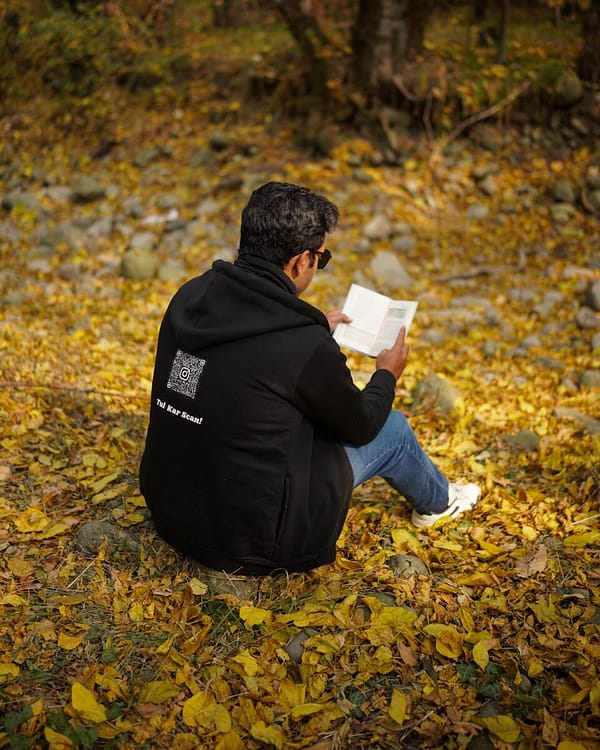 A man reading a book on fallen autumn leaves in New Theed, Kashmir.